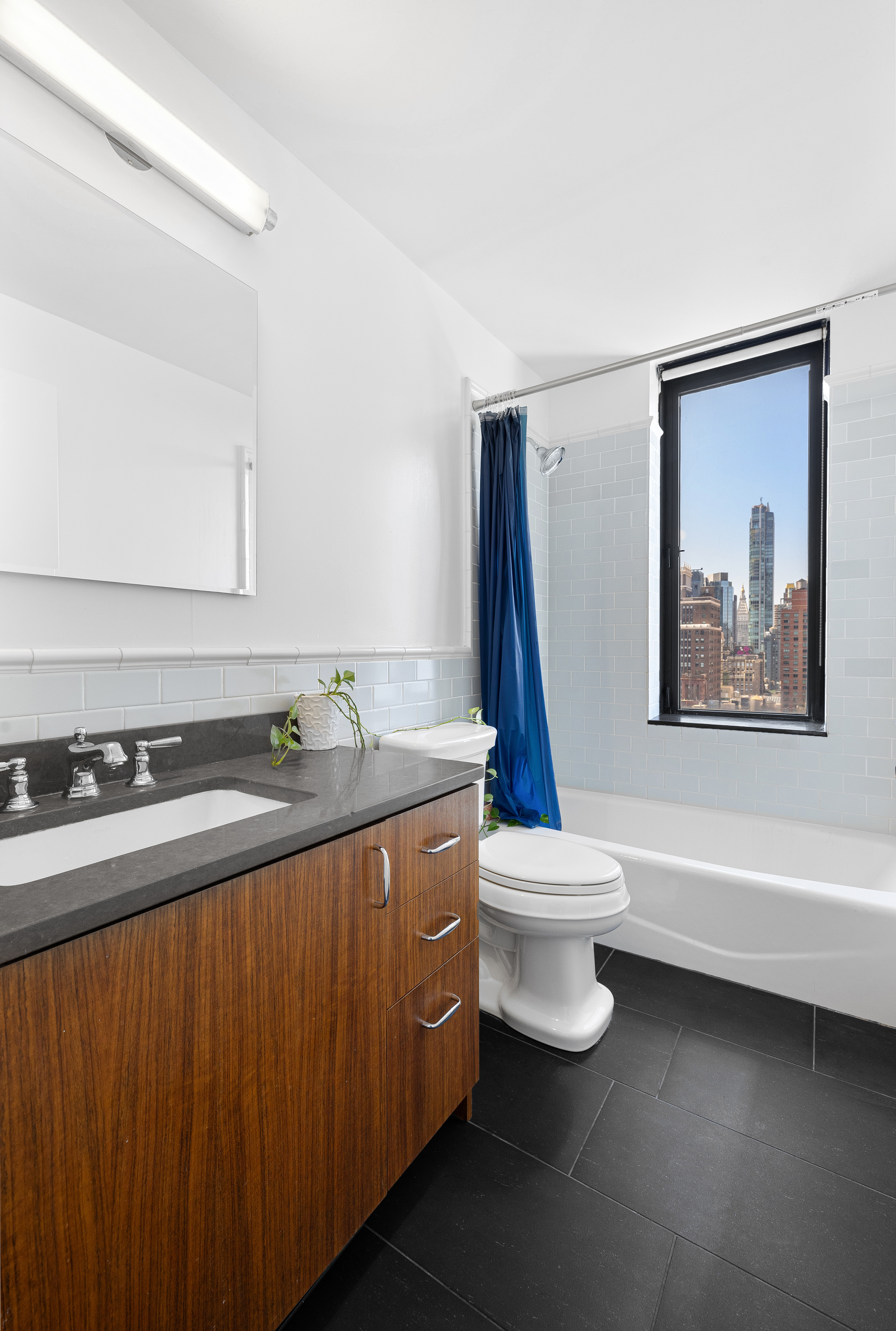 445 5th Avenue, Unit 26F Manhattan, NY 10016 - Photo 7 of 11 a bathroom with a sink a toilet and a bathtub