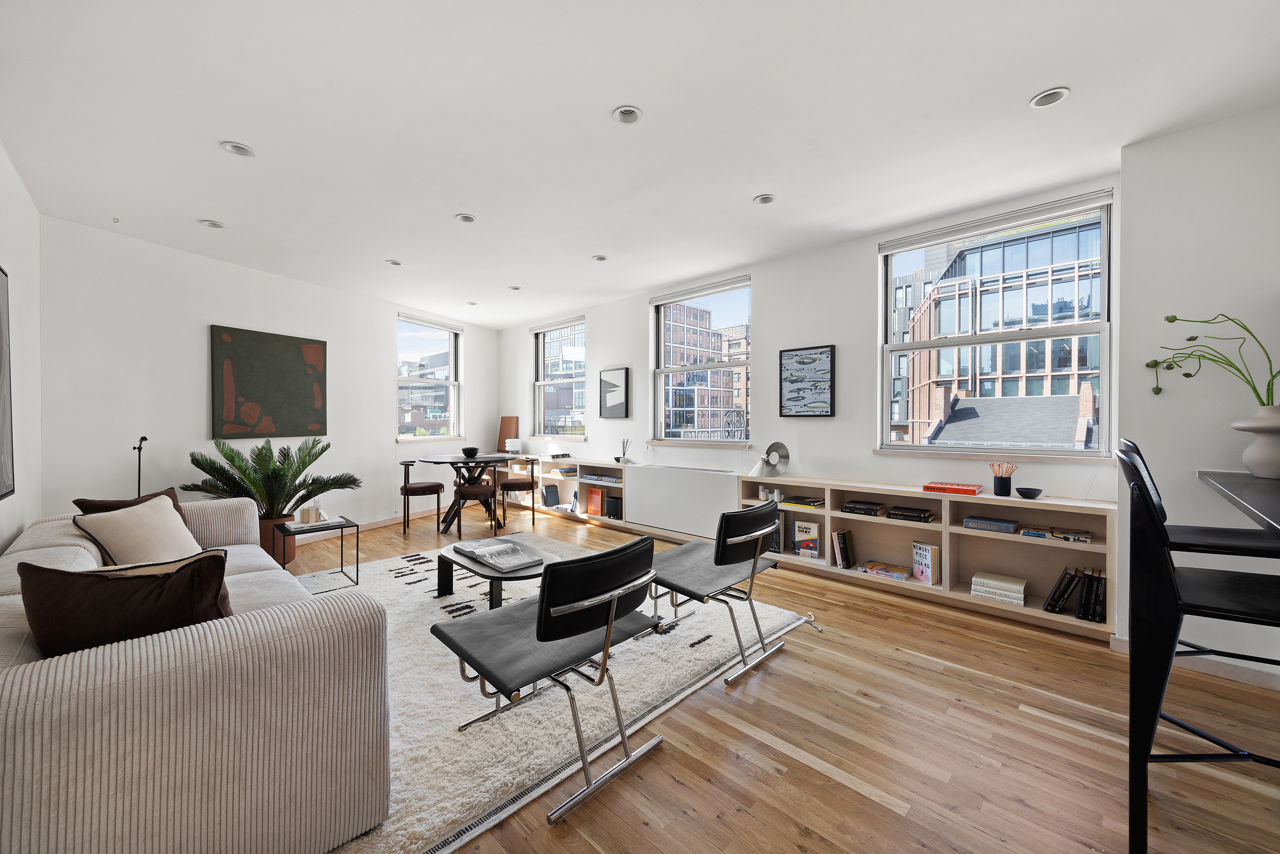 a living room with furniture kitchen view and a wooden floor