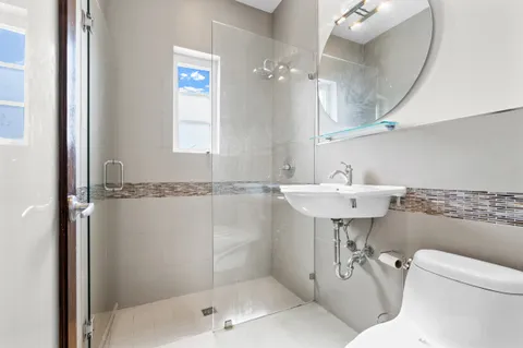 a bathroom with a sink mirror and toilet