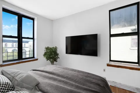 a bedroom with a bed and a flat screen tv