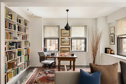 a living room with furniture and a book shelf