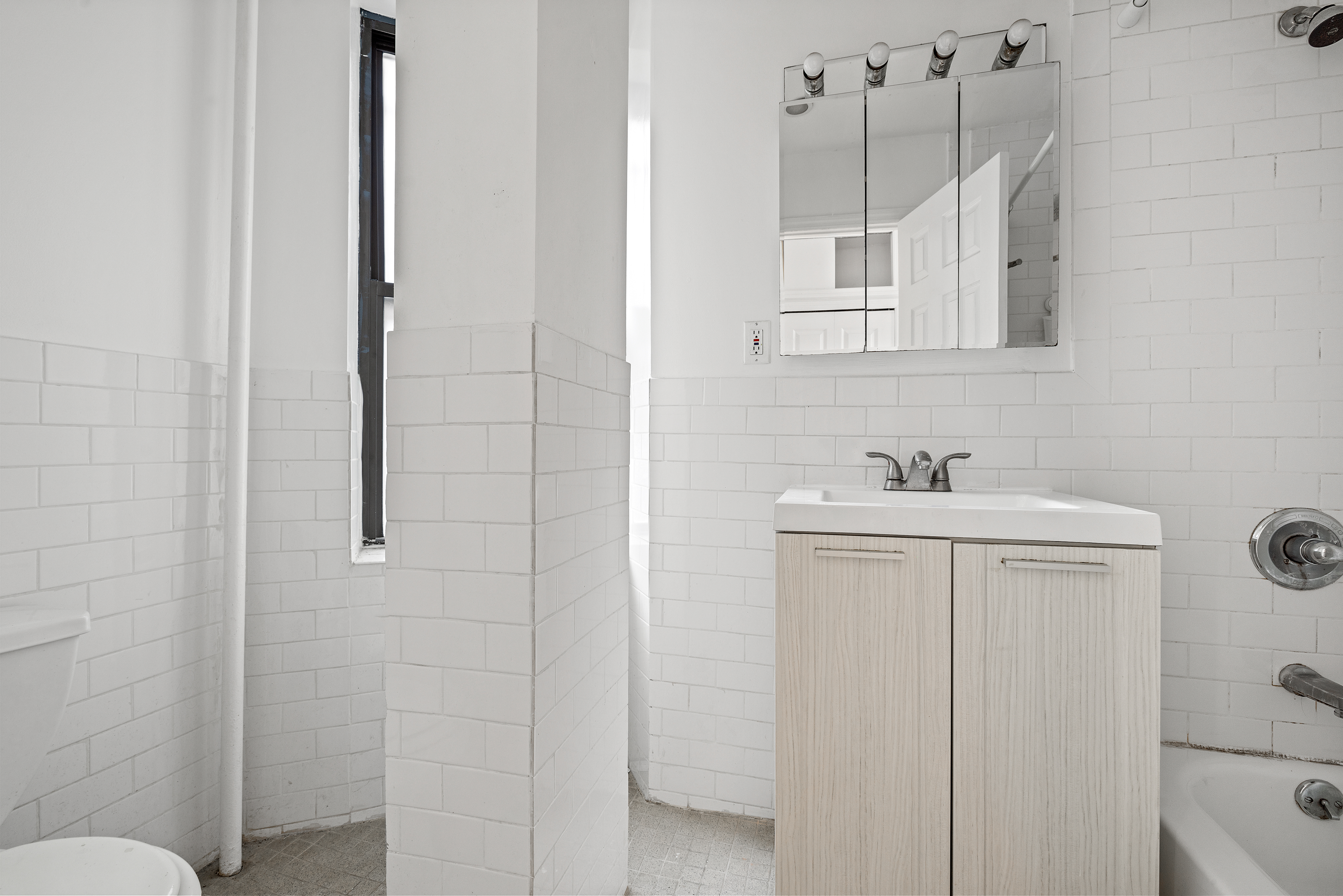 117 Henry Street, Unit 12A Manhattan, NY 10002 - Photo 4 of 5 a bathroom with a sink a toilet and shower