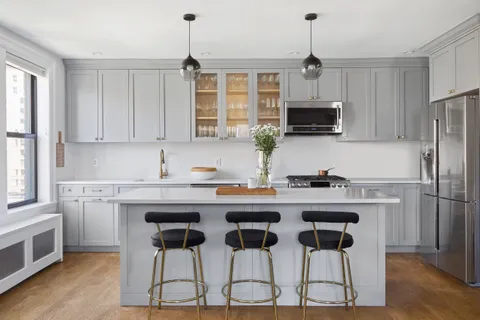 a kitchen with granite countertop white cabinets and stainless steel appliances