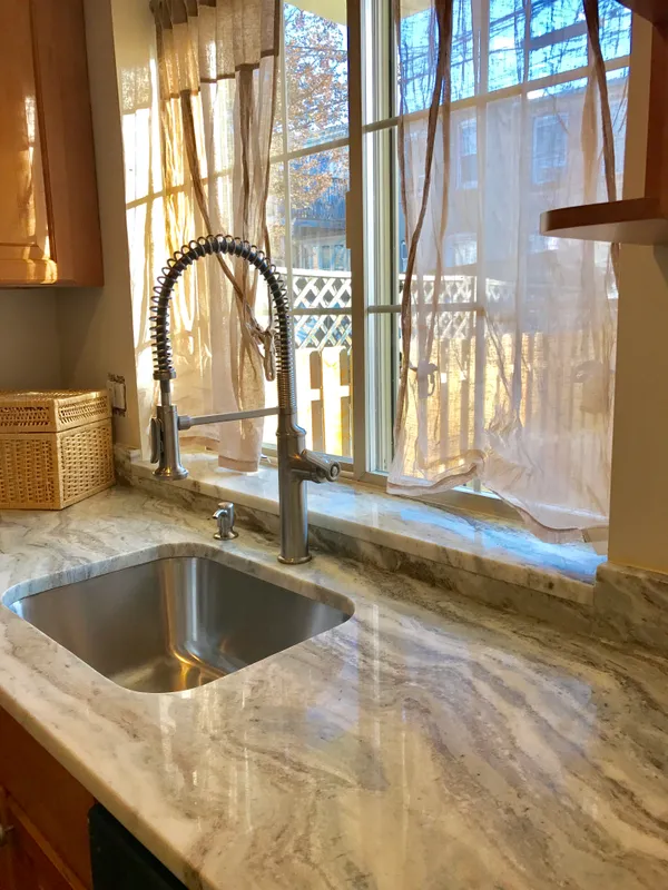 a view of a kitchen with a sink and large window