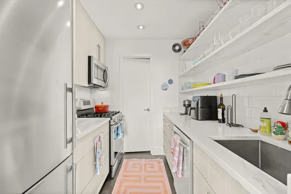 a utility room with stainless steel appliances granite countertop a sink and dishwasher