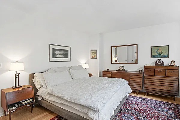 222 Riverside Drive, Unit 5D Manhattan, NY 10025 - Photo 3 of 8 a bedroom with a bed and a lamp on dresser