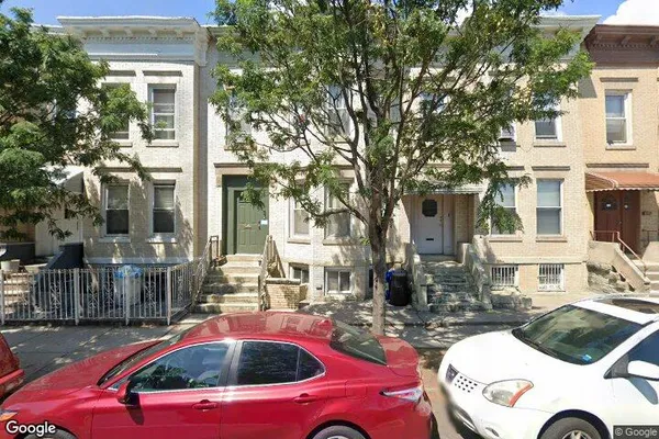 a front view of a house with cars parked