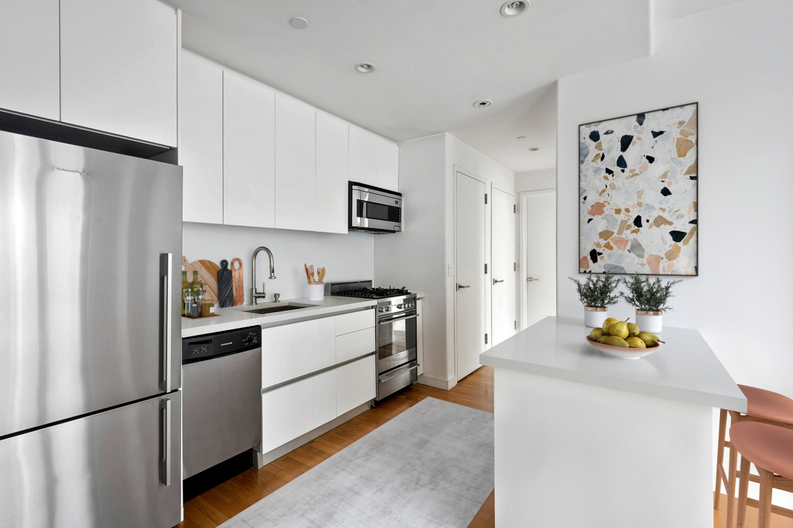 148 East 24th Street, Unit 6E Manhattan, NY 10010 - Photo 3 of 12 a kitchen with stainless steel appliances granite countertop a refrigerator and a stove top oven