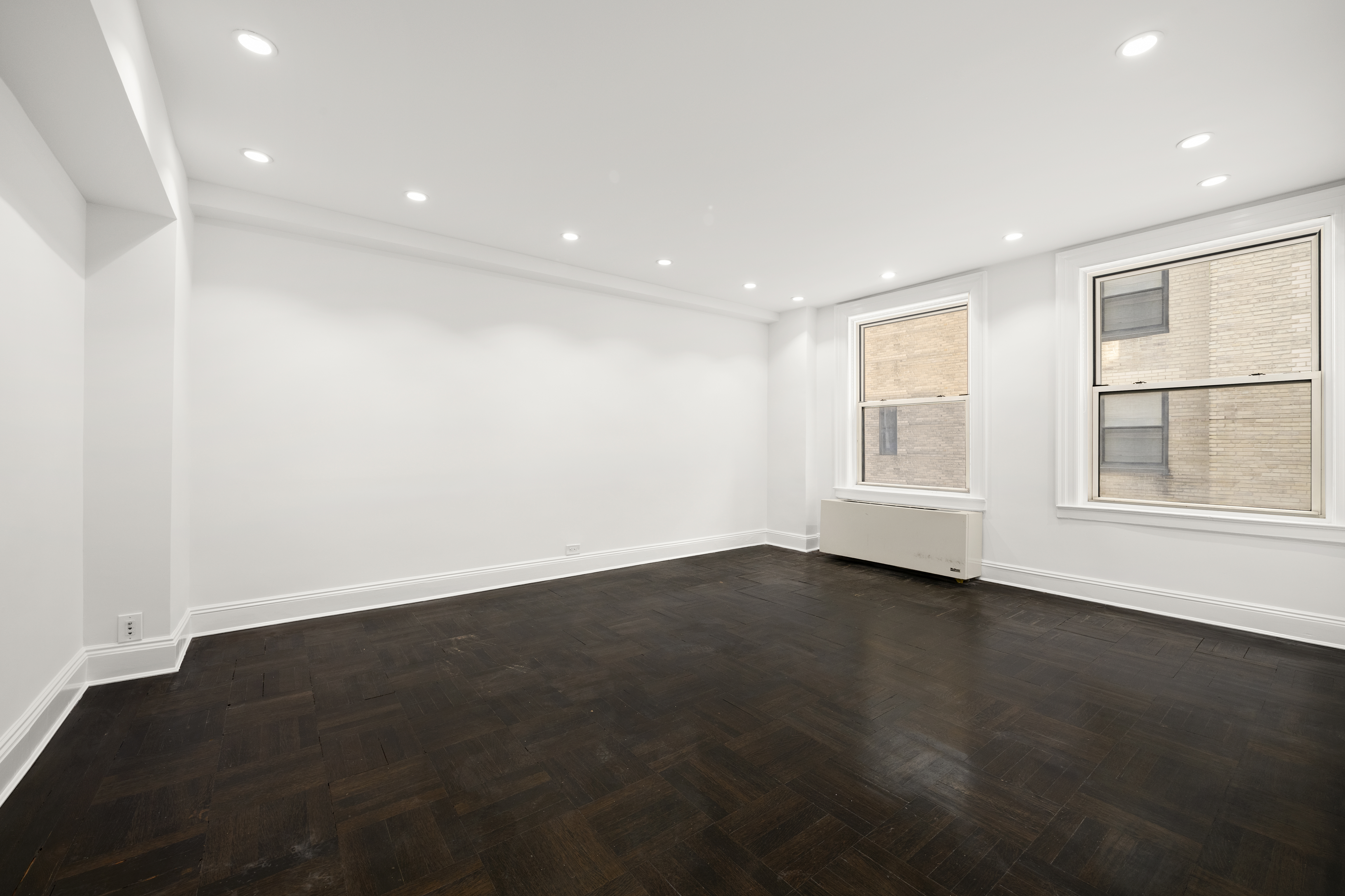 110-118 Riverside Drive, Unit 15C Manhattan, NY 10024 - Photo 2 of 6 an empty room with wooden floor and windows