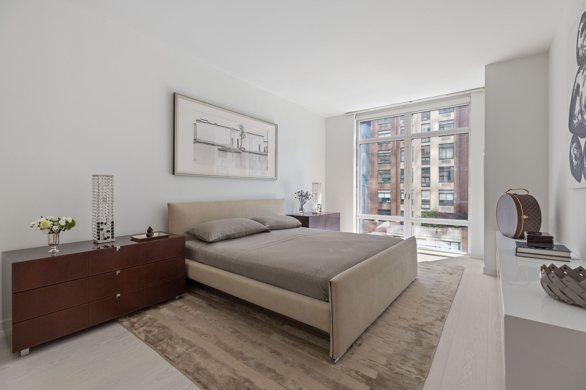 207 East 57th Street, Unit 14B Manhattan, NY 10022 - Photo 4 of 8 a spacious bedroom with a bed and a flat tv screen on the dresser