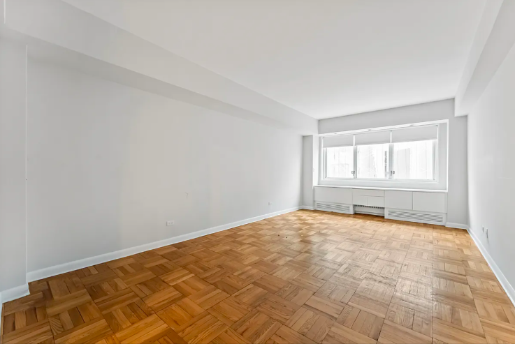 20 East 68th Street, Unit 11B Manhattan, NY 10065 - Photo 3 of 10 wooden floor in an empty room with a window