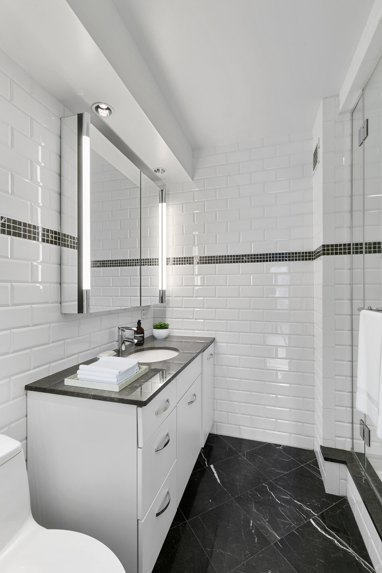 411 East 53rd Street, Unit 19D Manhattan, NY 10022 - Photo 5 of 13 a bathroom with a sink and a mirror