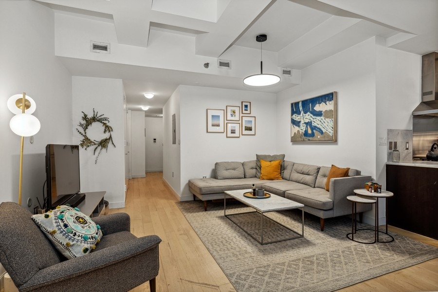 119 Fulton Street, Unit 2B Manhattan, NY 10038 - Photo 4 of 10 a living room with furniture and a flat screen tv