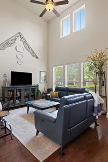 a living room with a couch a flat screen tv and a large window
