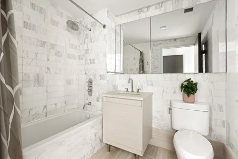 a bathroom with a granite countertop toilet sink and mirror