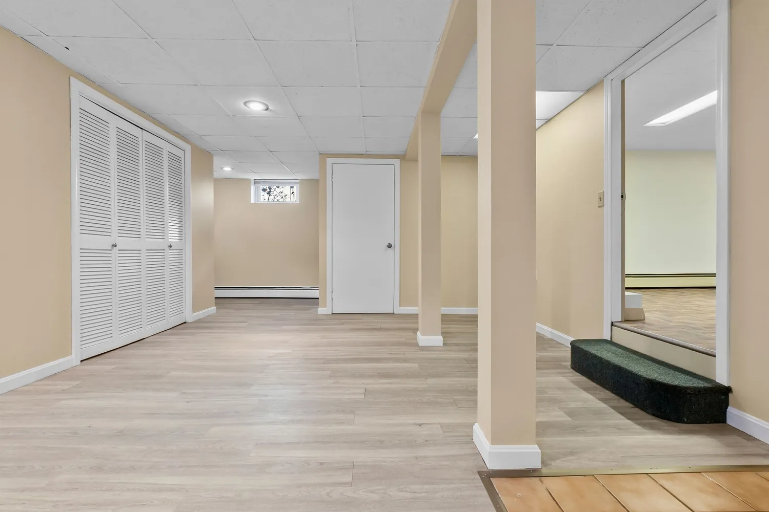 a view of a hallway with wooden floor and closet