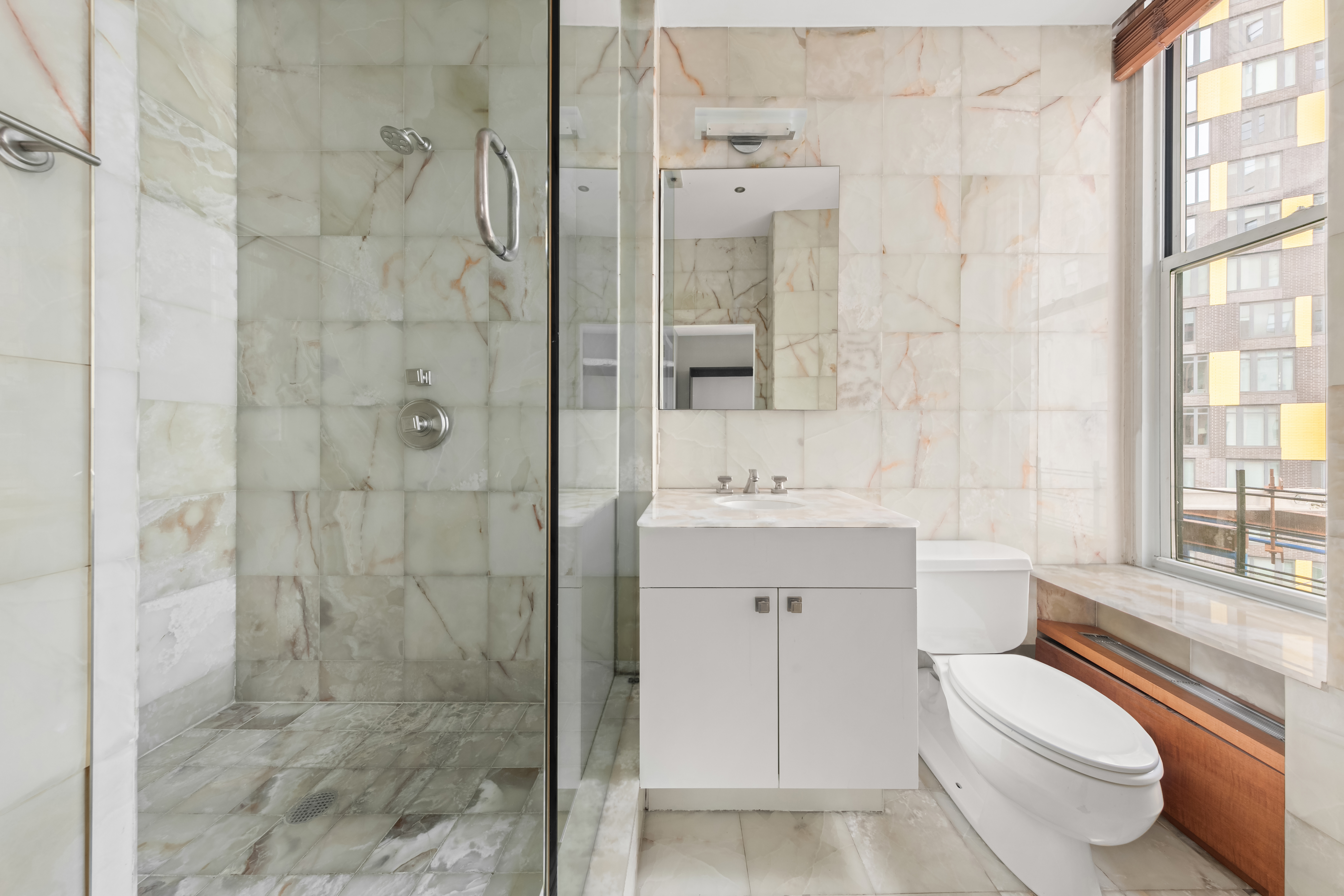 3 Hanover Square, Unit 22A Manhattan, NY 10004 - Photo 16 of 19 a bathroom with a sink toilet a shower and a mirror