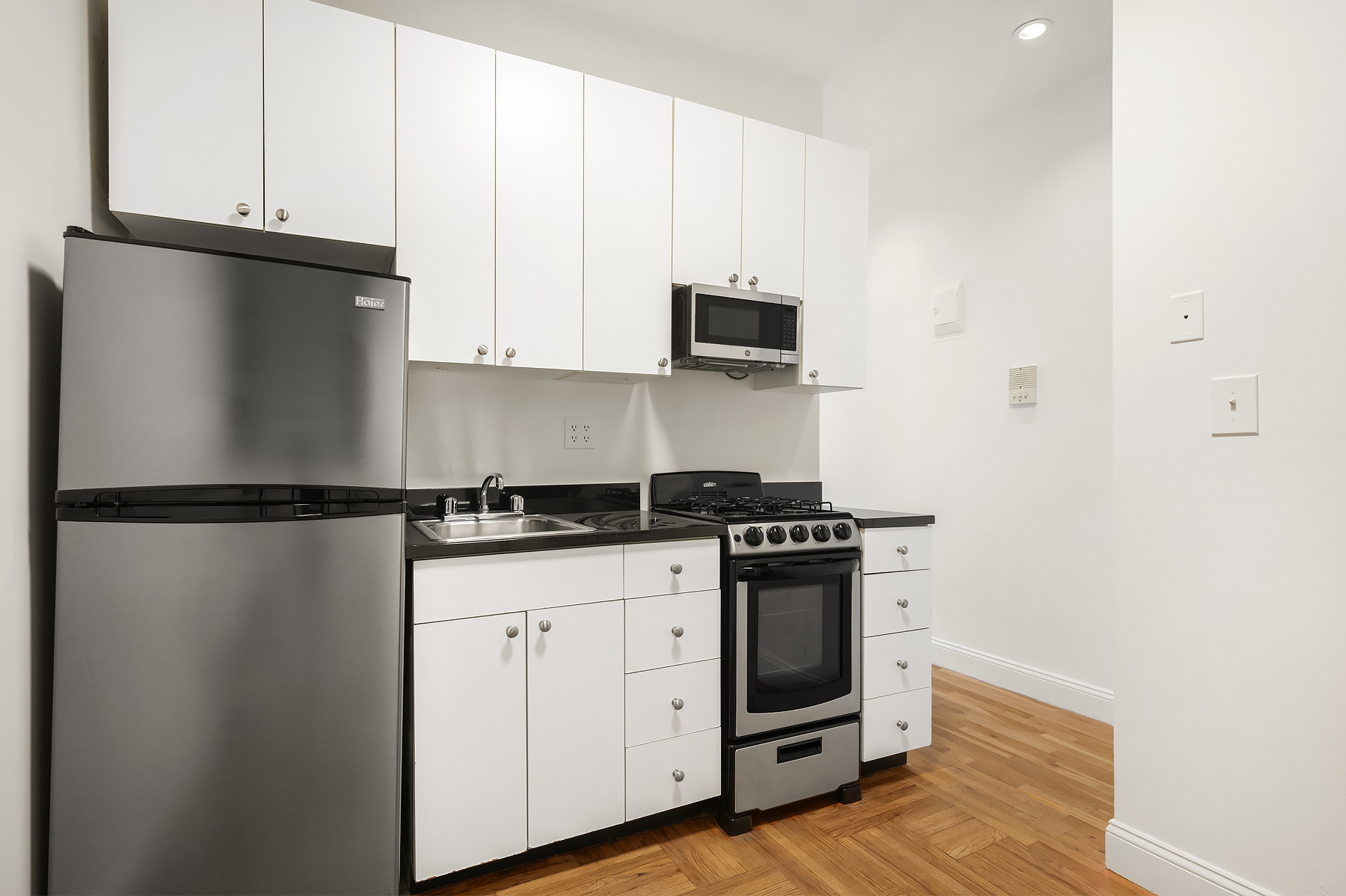 195 Prince Street, Unit 2W Manhattan, NY 10012 - Photo 2 of 9 a kitchen with stainless steel appliances a refrigerator sink and cabinets