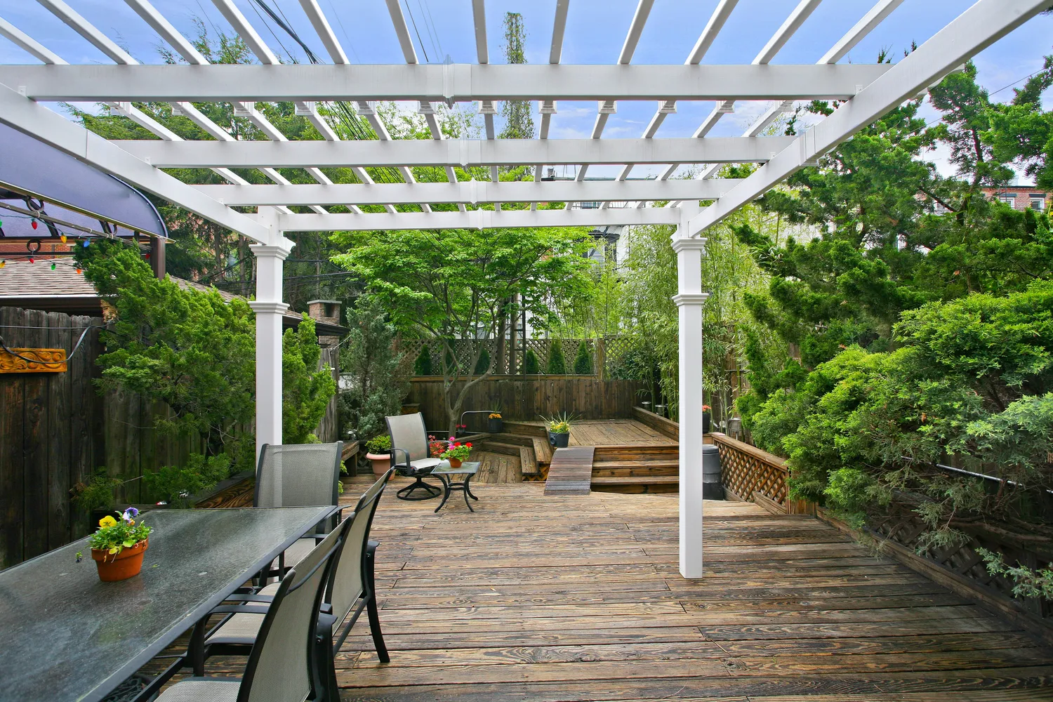 a view of a patio with table and chairs potted plants with wooden floor