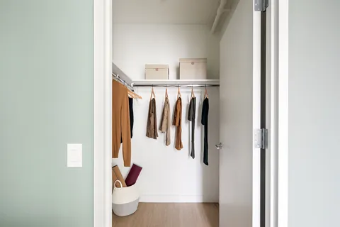 a view of walk in closet with clothes and shoes
