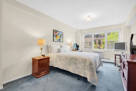 a bedroom with a bed wall painting and a window