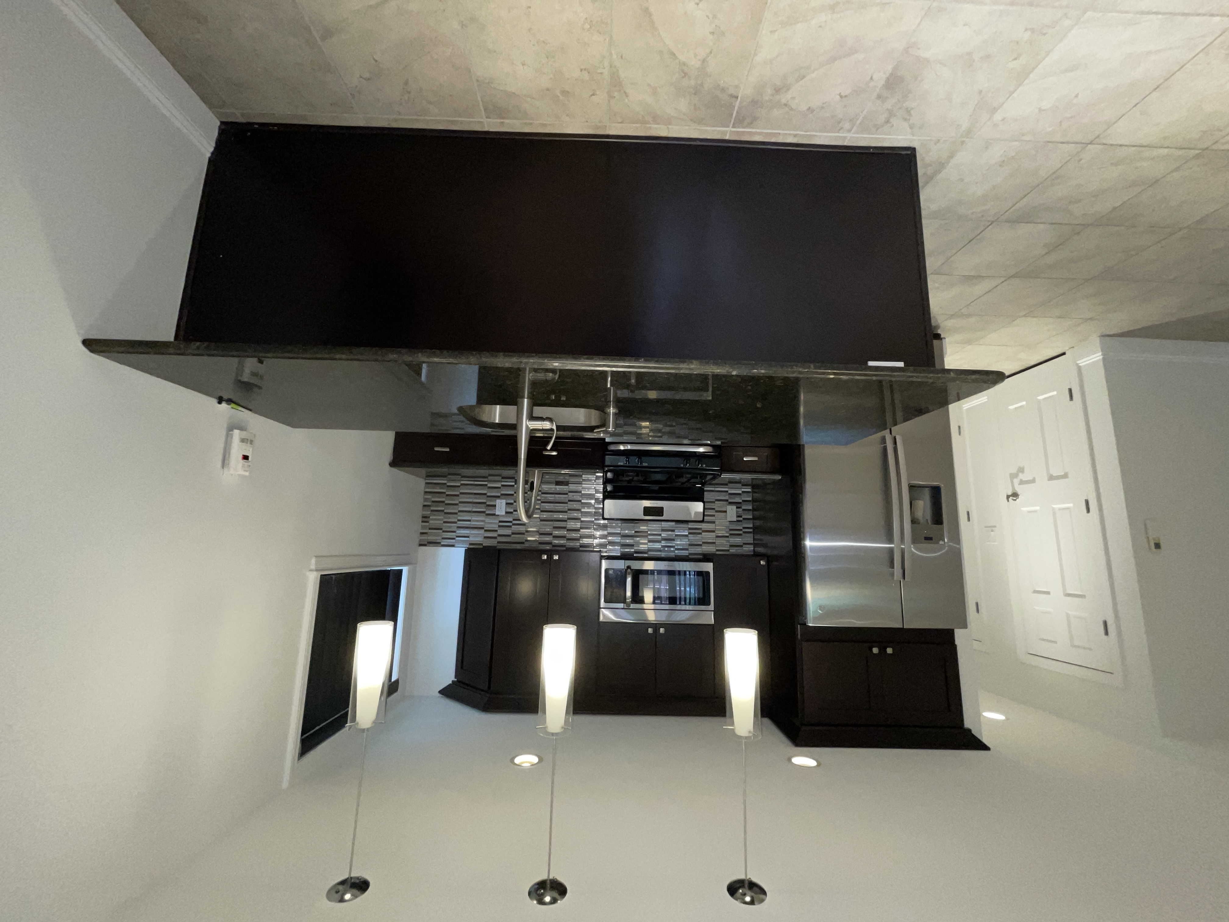 19-14 Astoria Park South, Unit 1B Queens, NY 11102 - Photo 5 of 11 a kitchen with stainless steel appliances granite countertop a refrigerator a sink a stove and a microwave