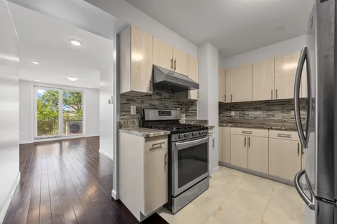 a kitchen with granite countertop a stove top oven sink and cabinets