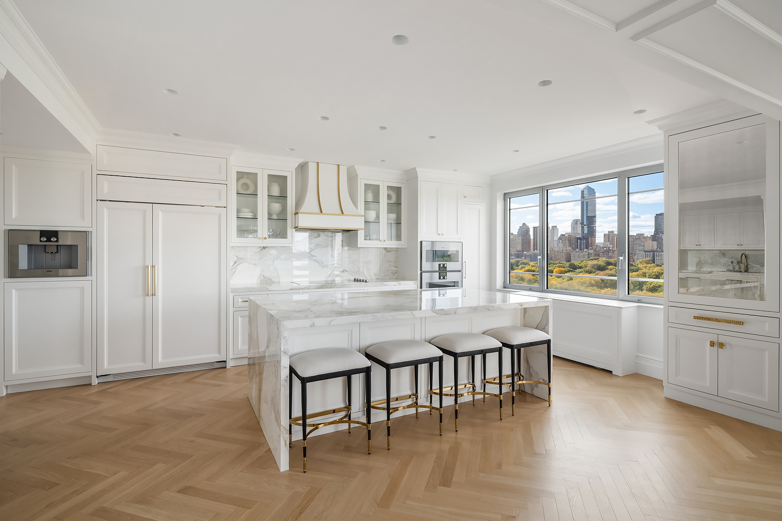 930 5th Avenue, Unit 18A Manhattan, NY 10021 - Photo 4 of 16 a kitchen with stainless steel appliances granite countertop a stove a sink a refrigerator and white cabinets with wooden floor
