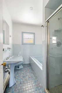 a bathroom with a sink a toilet and shower