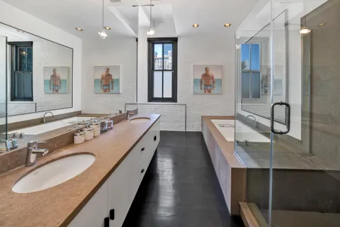 a bathroom with a double vanity sink a mirror and a bathtub