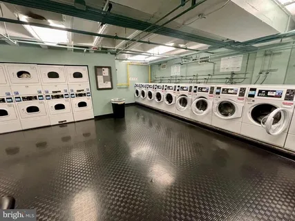 a utility room with stainless steel appliances kitchen island granite countertop a stove and a more cabinets