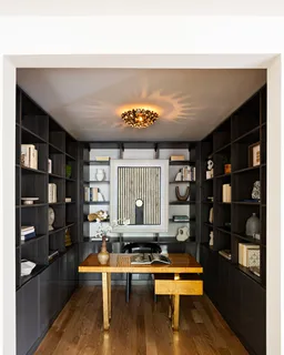 a living room with furniture a rug and a book shelf