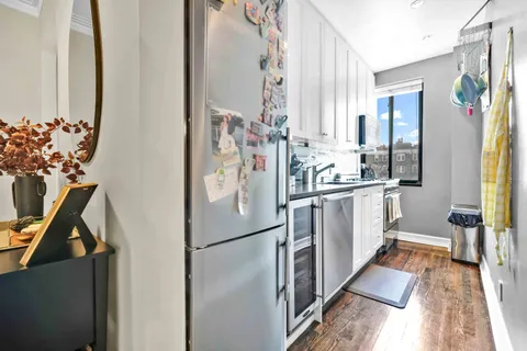 a kitchen with white cabinets and refrigerator
