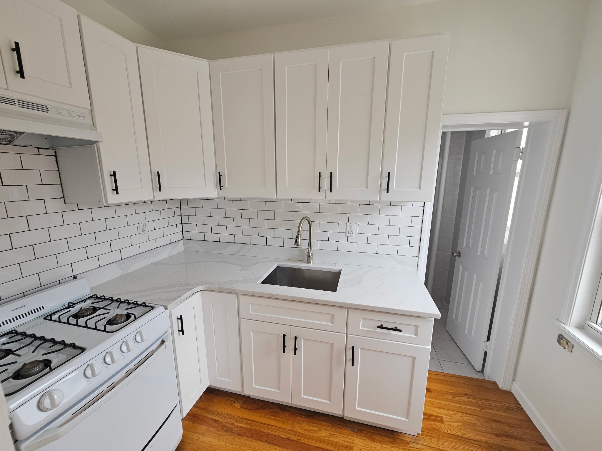 454 Lorimer Street, Unit 3 Brooklyn, NY 11206 - Photo 3 of 4 a kitchen with white cabinets sink and appliances