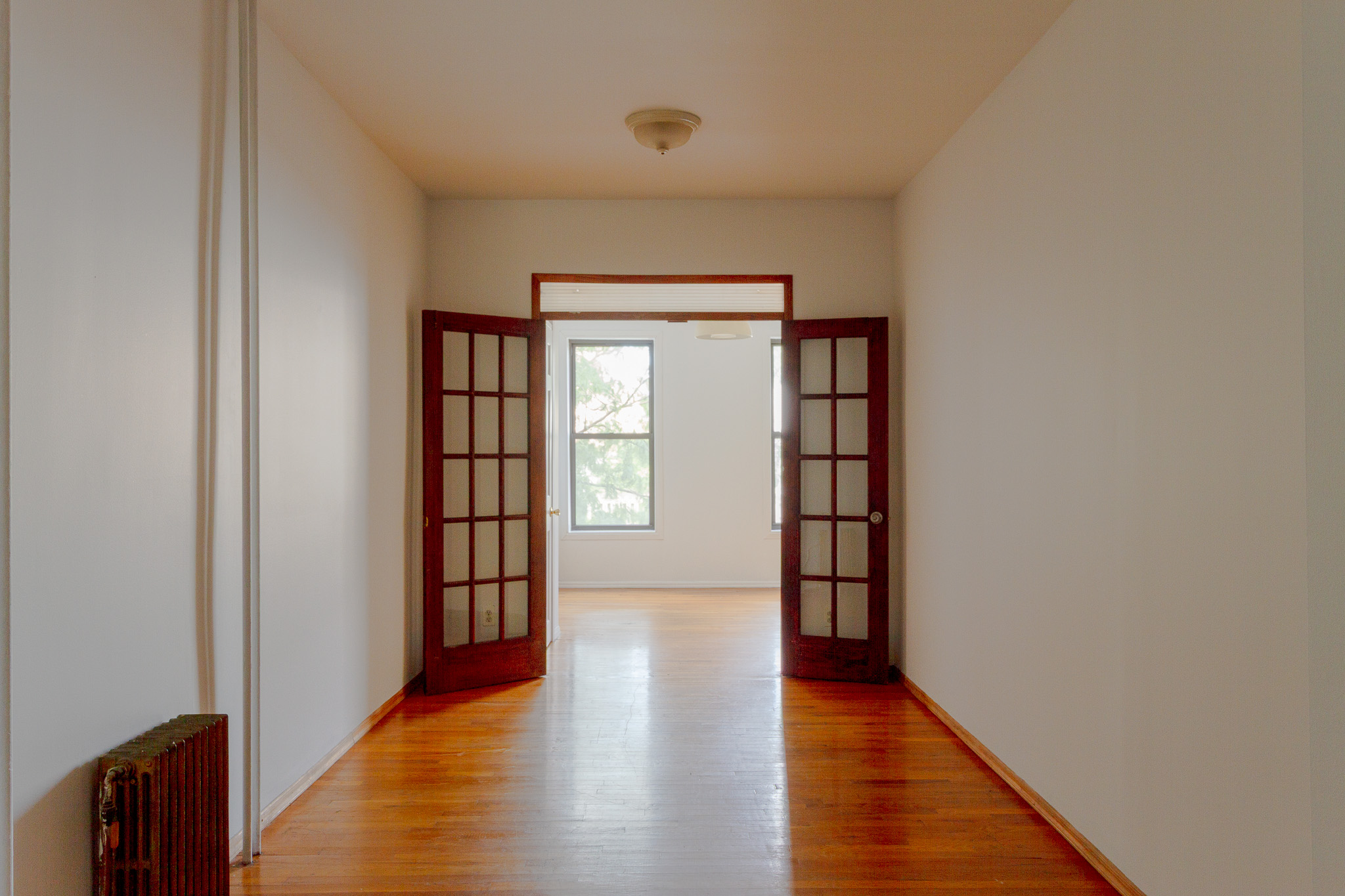 312 Prospect Avenue, Unit 2R Brooklyn, NY 11215 - Photo 2 of 10 a view of an empty room with wooden floor and a window