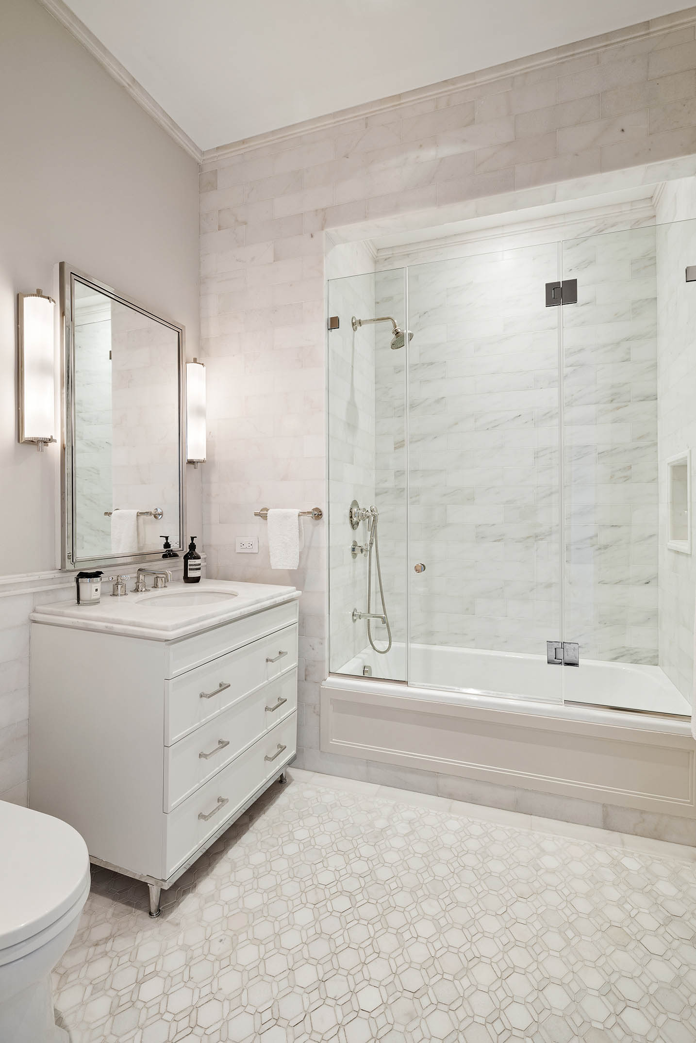 212 West 18th Street, Unit 14A Manhattan, NY 10011 - Photo 14 of 17 a bathroom with a double vanity sink toilet mirror and bathtub