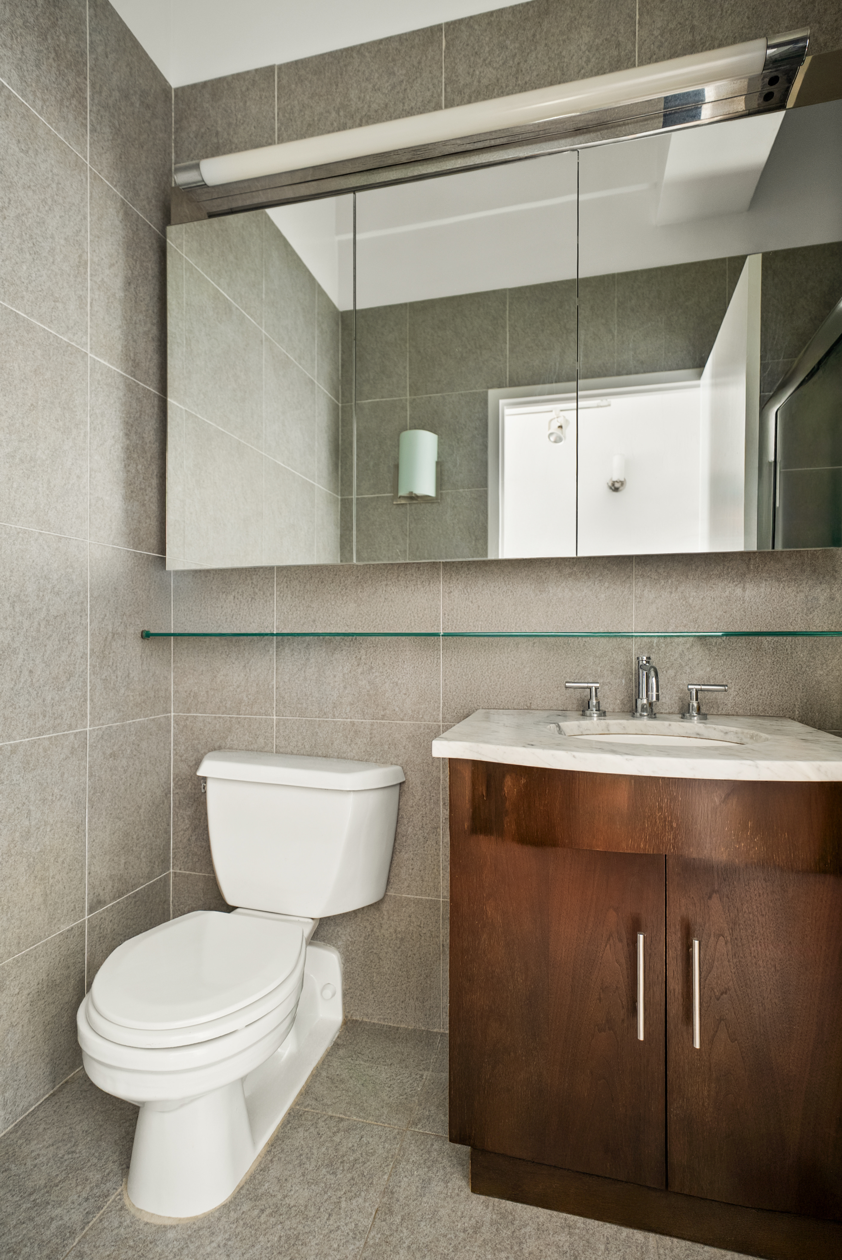 80 John Street, Unit 8H Manhattan, NY 10038 - Photo 5 of 6 a bathroom with a toilet a sink and mirror