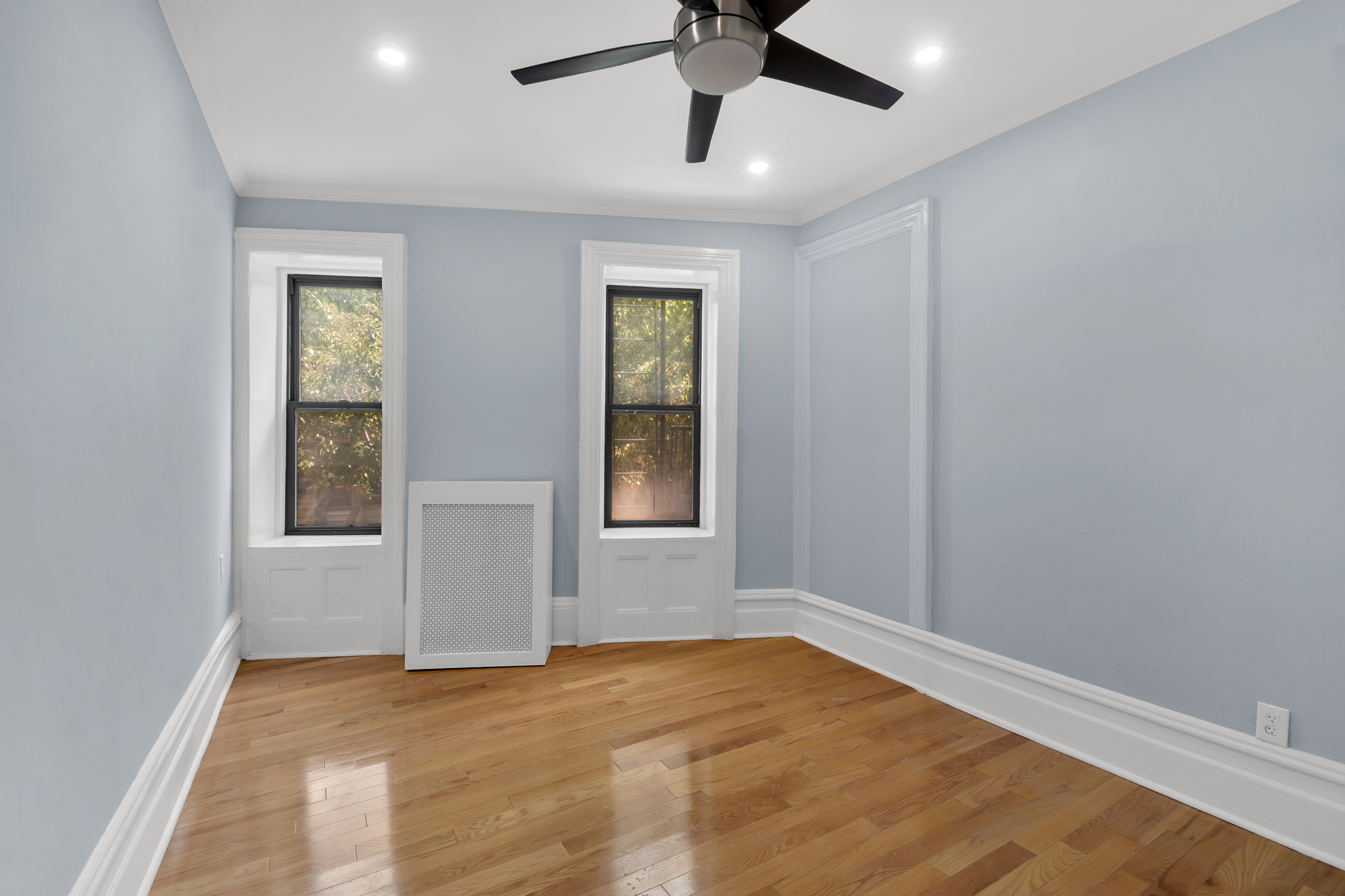 100 Hamilton Place, Unit 2F Manhattan, NY 10031 - Photo 14 of 21 an empty room with a window and a ceiling fan
