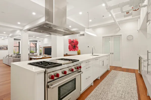 a kitchen with stainless steel appliances granite countertop a stove and a white cabinets