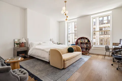 a bedroom with furniture and a large window