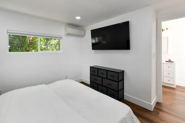 a bedroom with a bed and a flat screen tv