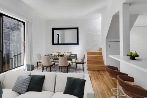 a living room with furniture wooden floor and a large window