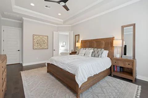 a bedroom with a large bed and a chandelier