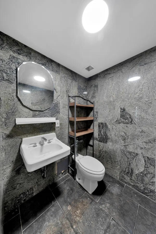 a bathroom with a sink toilet and mirror