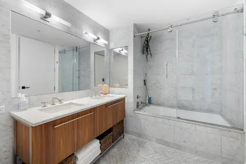 a bathroom with a double vanity sink mirror double and shower