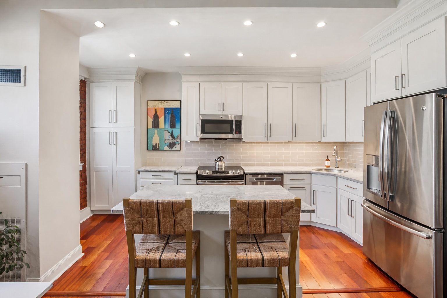 2123 California Street Northwest, Unit D5 Washington, DC 20008 - Photo 5 of 25 a kitchen with stainless steel appliances granite countertop a stove a sink a microwave a refrigerator with white cabinets and wooden floor