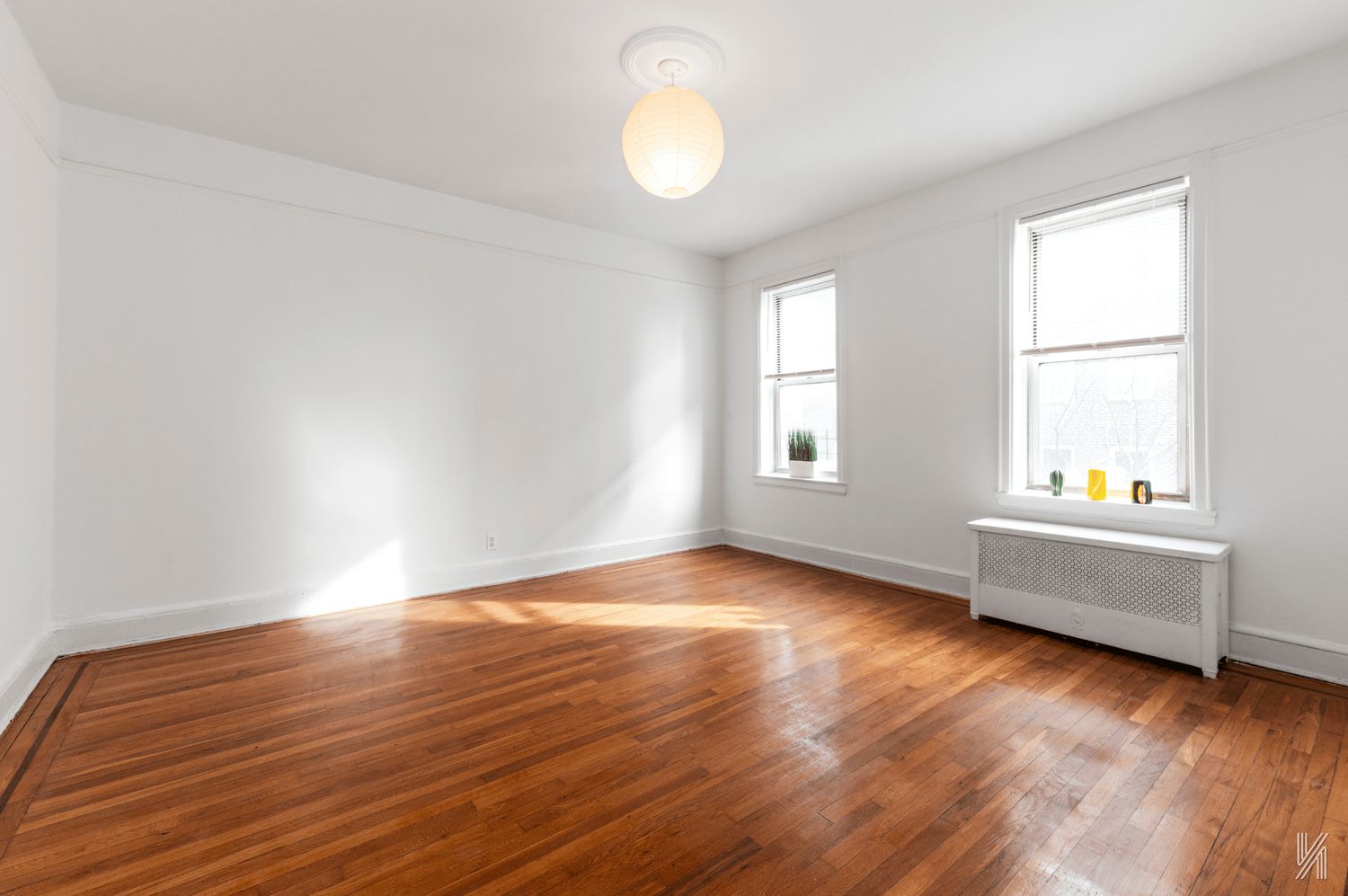 59-11 Queens Boulevard, Unit 3J Queens, NY 11377 - Photo 10 of 18 an empty room with wooden floor and windows
