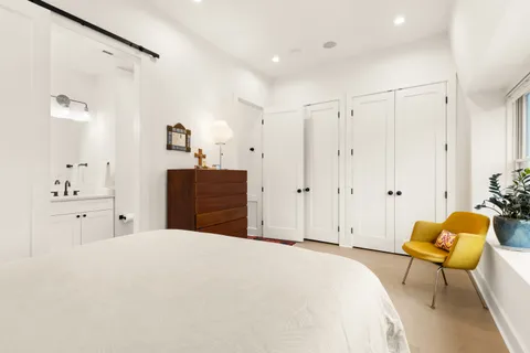 a spacious bedroom with a bed and a chandelier