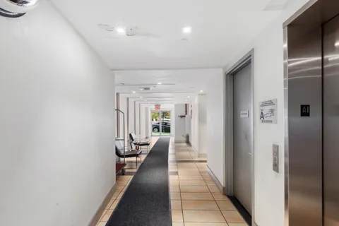 a hallway with white doors wooden floor and glass door