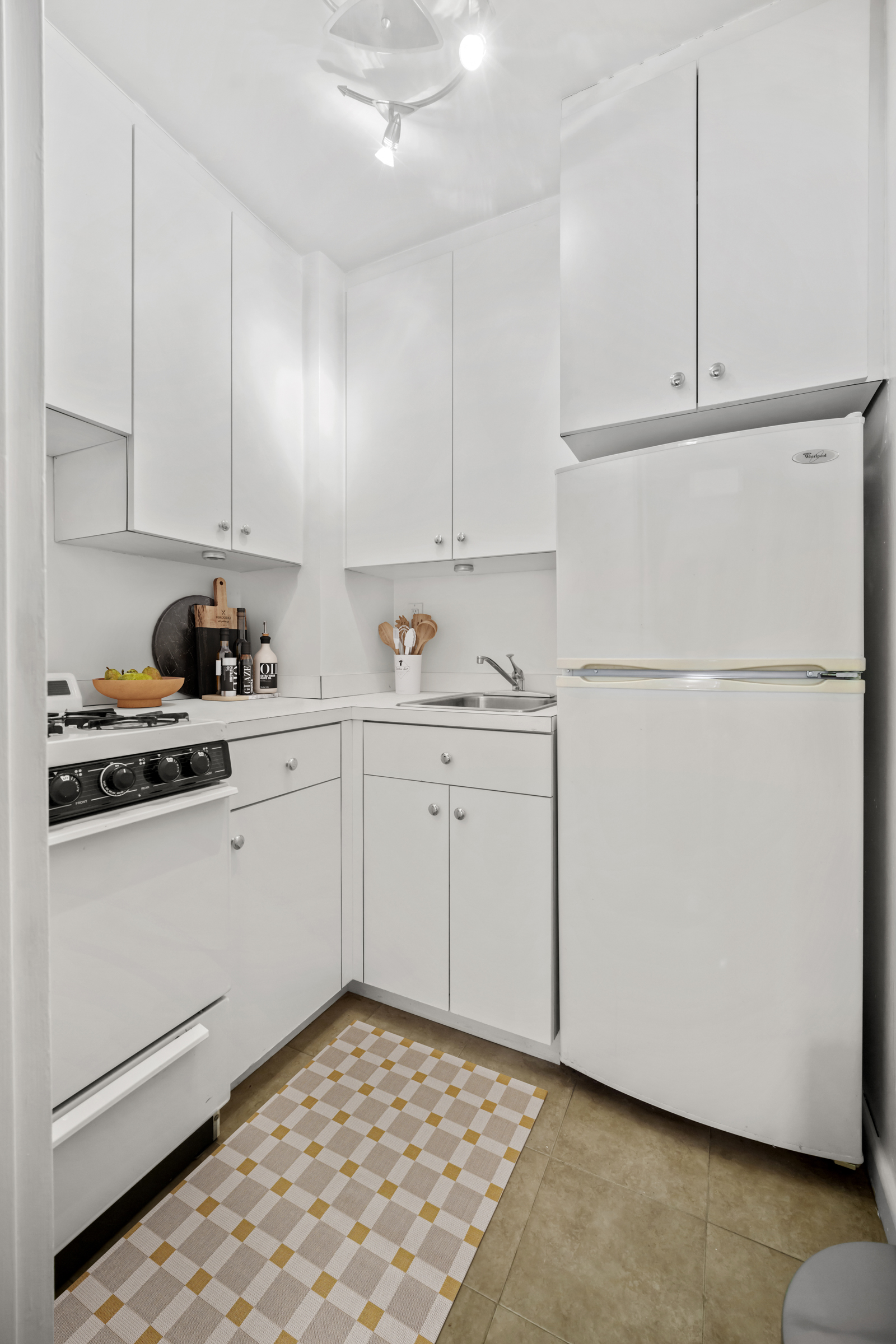 210 East 63rd Street, Unit 5B Manhattan, NY 10065 - Photo 4 of 6 a kitchen with white cabinets and white appliances